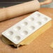 A tray of dough with a rolling pin.