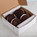 A box of chocolate chip cookies in a white bakery box.