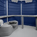 A dark blue PolyJohn wheelchair accessible portable toilet with a seat and a lid.