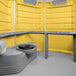 A yellow and grey PolyJohn wheelchair accessible portable restroom.