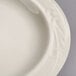 A close-up of a Homer Laughlin ivory china plate with a curved edge.