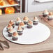 A group of cupcakes on a white 18" corrugated cake circle.