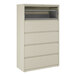 A beige five-drawer lateral file cabinet with a roll-out binder storage compartment at the top.