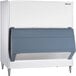 A white Follett upright ice storage bin with a blue panel.