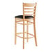 A Lancaster Table & Seating wooden ladder back bar stool with black vinyl seat