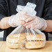 A person holding a plastic bag of bagels.