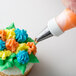 A cupcake with frosting piped in the shape of a flower using an Ateco drop flower piping tip.