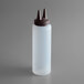 A plastic bottle with a clear cap with twin tips on a brown cap.