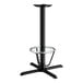 A black cast iron bar height table base with a foot ring.