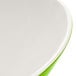 A white melamine bowl with a green interior and white rim.