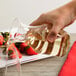 A hand pouring white wine from a WNA Comet clear plastic wine carafe into a glass.