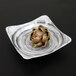 An artichoke on a square black Elite Global Solutions melamine bowl.