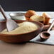 A bowl of flour with a wooden spoon.