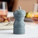 An Acopa steel blue wooden pepper mill on a table.