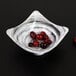 A white Elite Global Solutions square melamine bowl filled with cranberries.