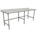 A stainless steel Advance Tabco work table with an open base and a metal bar.