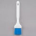 A white Carlisle Sparta Spectrum pastry brush with a blue tip.