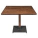 A Lancaster Table & Seating wooden table with a metal base.