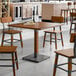 A Lancaster Table & Seating live edge wood table with metal legs and chairs.