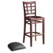 A Lancaster Table & Seating mahogany wood bar stool with a detached black vinyl seat.