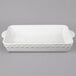 A white rectangular Tuxton casserole dish with handles.