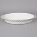 A white oval Tuxton casserole dish with a silver rim.