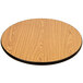 A Lancaster Table & Seating bar height table with a round wooden table top with a black edge on a cross cast iron base.