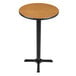 A Lancaster Table & Seating bar height table with a round walnut and oak top on a black base.