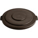 A brown circular lid on a Lavex commercial trash can.