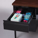 A Hirsh Industries right corner pedestal desk with a drawer full of stationery.