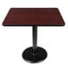A Lancaster Table & Seating table with a black base and a reversible cherry/black top.