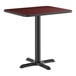 A standard height table with a reversible cherry and black rectangular top and a black cast iron base.