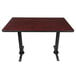 A Lancaster Table & Seating rectangular table with a reversible cherry/black top and black table base plates.