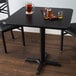 A Lancaster Table & Seating black table with a board game and glasses of beer on it.