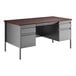 A charcoal gray metal double pedestal desk with mahogany drawers.