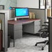 A charcoal and mahogany double pedestal desk with a computer on it.