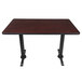 A Lancaster Table with a black base and cherry top on a bar table.