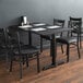 A Lancaster Table & Seating black table with a cherry table top and black chairs.