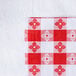 A red and white checkered Intedge vinyl table cover.