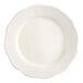 An ivory stoneware plate with a scalloped edge and a round center.