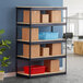 A Hirsh Industries black boltless shelving unit with boxes on the shelves.