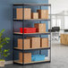 A black Hirsh Industries boltless shelving unit with boxes on the shelves.