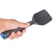 a hand holding a black plastic spatula