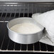 a person holding a bowl of food in an oven