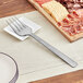 An American Metalcraft stainless steel cold meat fork on a plate with meat and crackers.