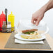 a sandwich in a clear container on a plate