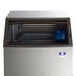 A grey Manitowoc undercounter ice machine with a clear glass door filled with square ice.