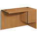 A HON Harvest laminate "L" right pedestal workstation return on a wooden desk with drawers.