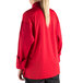 A woman wearing a red Mercer Culinary cook jacket with a mesh back.