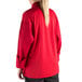 A woman wearing a Mercer Culinary red cook jacket with black pants.